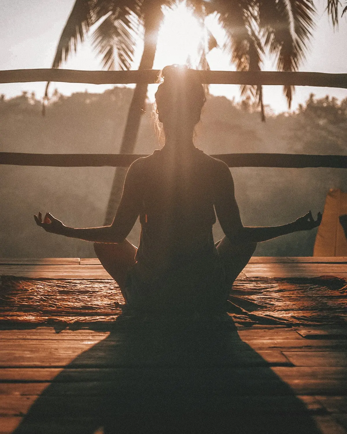 A person sitting in quiet meditation on a warm wooden floor, soft side light, unhurried