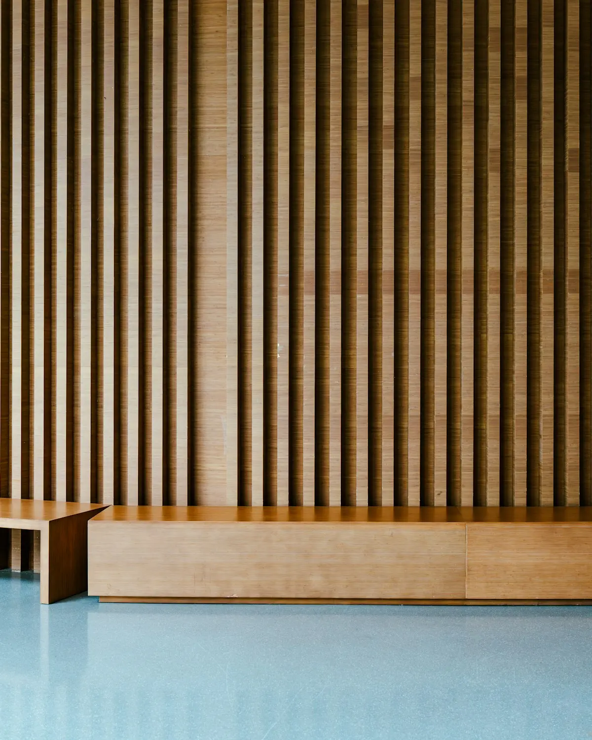 The warm wooden studio room with a slatted wall, soft daylight, calm and uncluttered