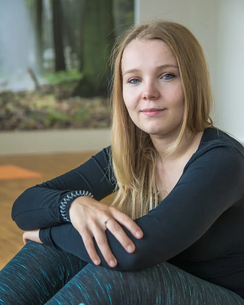 Portrait of Sofia, a woman seated on the floor in a calm pose, gentle and grounded