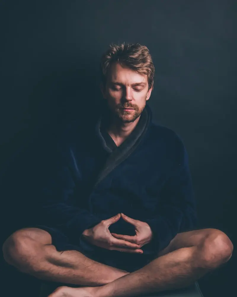 Portrait of Tom, a man seated and relaxed against a soft dark background, gentle expression
